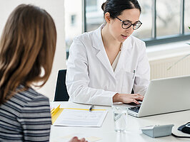 Apothekerin mit Patientin am Laptop Primary care physician typing on laptop useful observations