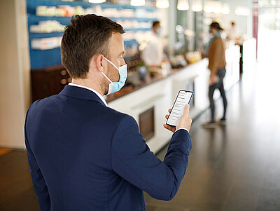 Mann mit Smartphone in der Apotheke